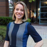 Alex Coffey stands outside the Georgia Experience Center surrounded by buildings with trees