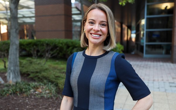 Alex Coffey stands outside the Georgia Experience Center surrounded by buildings with trees