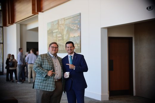 Two men smiling and pointing at each other at the Good News Gathering