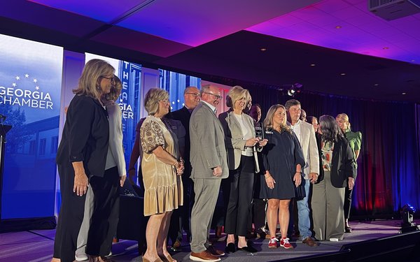 Group of professionals stand on a stage accepting an award at the GA Rural Prosperity Summit