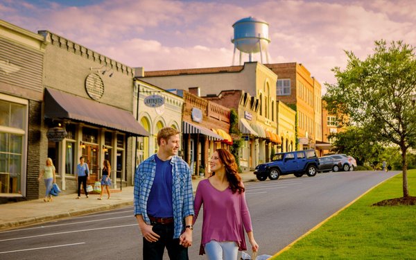 Couple holding hands down the street with a shopping bag in Senoia GA