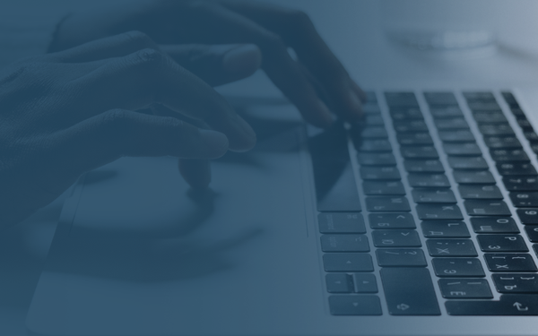 Two hands typing on a keyboard